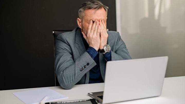 Manager frustrat în fața laptopului