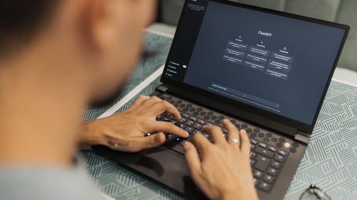 Persoană care scrie un prompt pe laptop